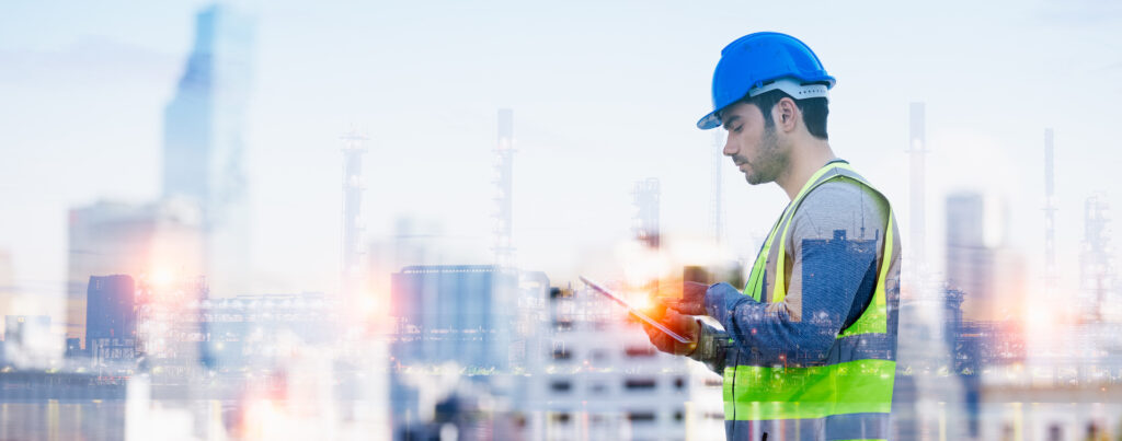 An industrial worker using a tablet in a construction site